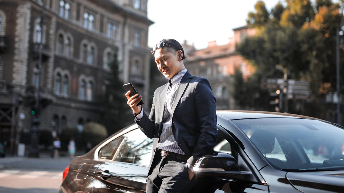 Automobilista genovese utilizza un&rsquo;app sullo smartphone accanto alla propria auto: la nuova constatazione amichevole digitale CAI 2026