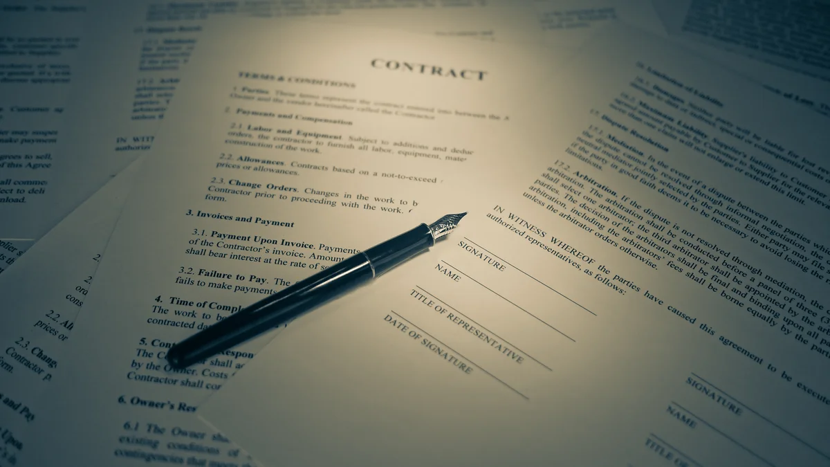 Contratto con clausole in piccolo e penna stilografica appoggiata sulla pagina delle firme